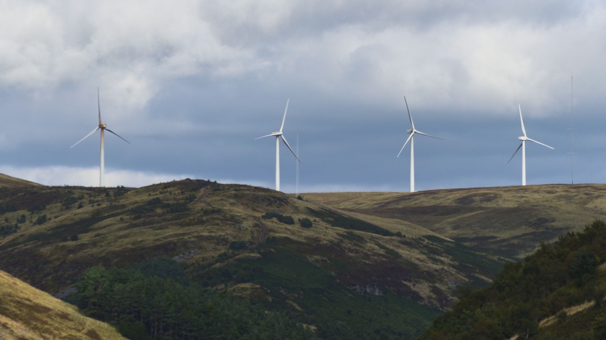 Wind turbines along a ridge under heavy cloud
