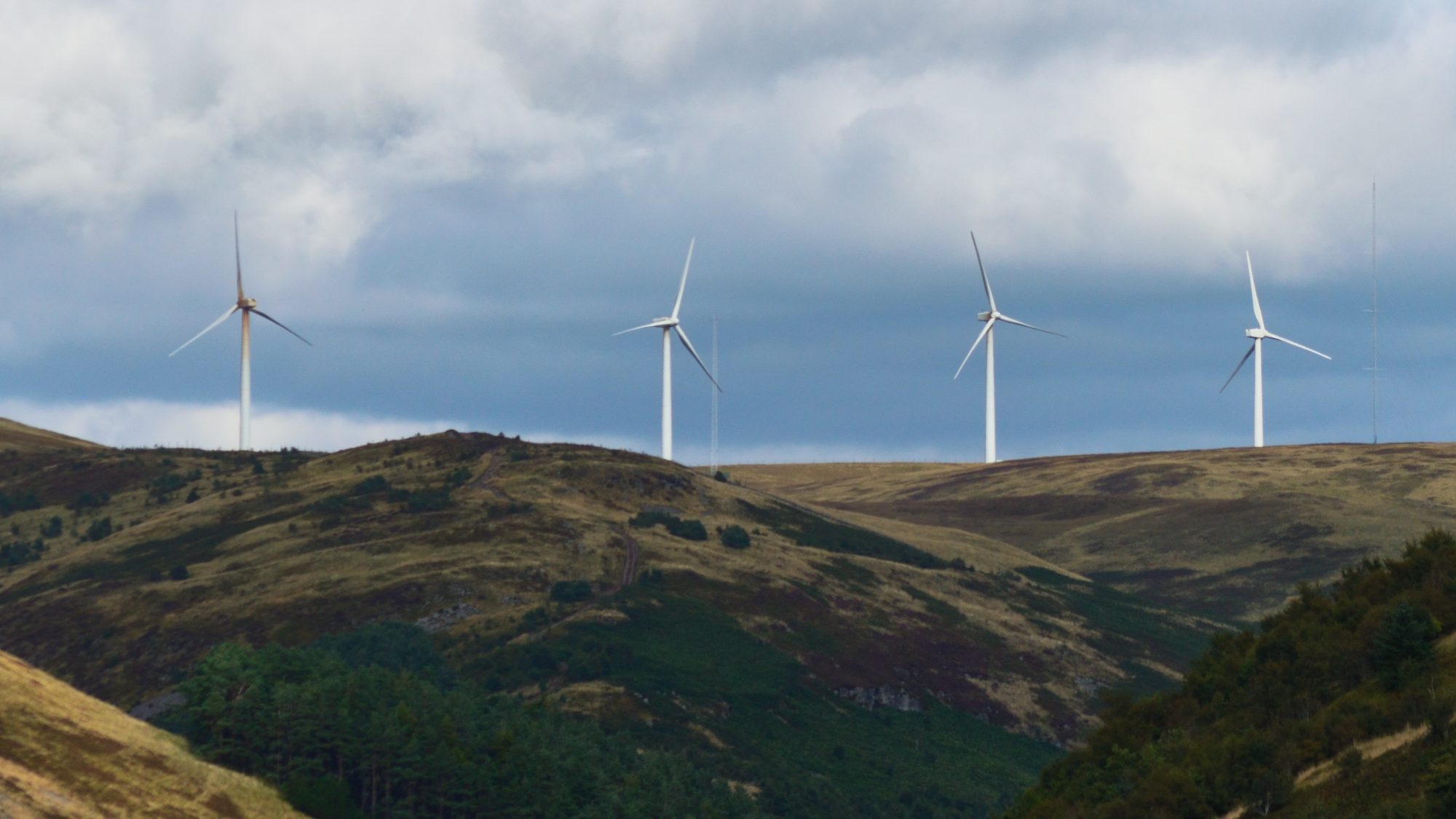 Wind turbines along a ridge under heavy cloud